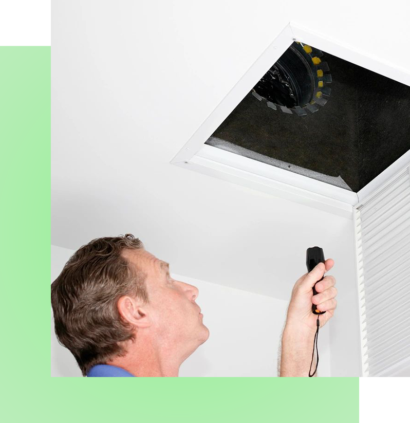 Mature man taking out a dirty air filter from a home ceiling air return vent